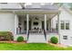 Elegant covered porch featuring an outdoor kitchen, dining area, and cozy seating with TV at 331 Anthony Cir, Charlotte, NC 28211