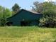 A rustic green barn surrounded by lush green grass and trees at 4194 Buffalo Shoals Rd, Maiden, NC 28650