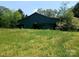 A rustic green barn surrounded by lush green grass and trees at 4194 Buffalo Shoals Rd, Maiden, NC 28650