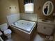 Bathroom featuring a tiled jacuzzi tub, vanity, mirror, and toilet under a window at 4194 Buffalo Shoals Rd, Maiden, NC 28650