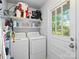 Functional laundry area with washer, dryer, shelving, and natural light creates an organized and efficient space at 500 Colony Acres Dr, Charlotte, NC 28217