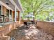 Relaxing side porch with an umbrella-covered table and chairs, perfect for outdoor dining at 500 Colony Acres Dr, Charlotte, NC 28217