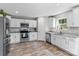 Bright kitchen features white cabinets, stainless steel appliances, granite countertops, and hardwood floors at 539 Morrison Farm Rd, Troutman, NC 28166