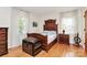 Serene bedroom featuring a wooden bed frame, hardwood floors, and lots of sunlight at 704 Kingman Dr, Charlotte, NC 28217