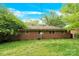 Exterior of brick home with a spacious backyard and mature trees, offering privacy and a peaceful setting at 735 Wilbrown Cir, Charlotte, NC 28217