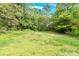 Enjoy this spacious backyard with green grass, lush trees, and blue sky at 735 Wilbrown Cir, Charlotte, NC 28217