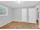 Bedroom with hardwood floors, two entry doors, and a window for natural light at 735 Wilbrown Cir, Charlotte, NC 28217