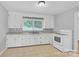 Bright kitchen with white cabinets, tile flooring, and ample countertop space at 735 Wilbrown Cir, Charlotte, NC 28217