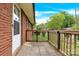 Cozy covered patio featuring brick siding and wood railing, perfect for outdoor relaxation at 735 Wilbrown Cir, Charlotte, NC 28217