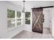 Charming dining room with a barn door, a modern chandelier, and natural light at 8027 Bristle Ln, Charlotte, NC 28214