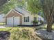 Charming home with white siding, brick accents, a two-car garage, and lush landscaping in a well-maintained yard at 8027 Bristle Ln, Charlotte, NC 28214
