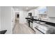 Bright kitchen features white cabinets, stainless steel appliances and plank flooring at 8027 Bristle Ln, Charlotte, NC 28214