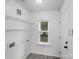 Bright laundry room features utility sink, window and storage shelves at 8027 Bristle Ln, Charlotte, NC 28214