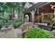 Inviting covered back patio with stone fireplace, swing, and view of stone patio and lush landscaping at 809 Verney Ln, Charlotte, NC 28226