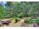 Lush backyard featuring a stone patio with an outdoor dining area and a tranquil waterfall pool at 809 Verney Ln, Charlotte, NC 28226