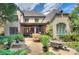 Expansive brick home with a covered patio, stone water feature and outdoor seating surrounded by greenery at 809 Verney Ln, Charlotte, NC 28226