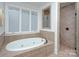 Bathroom featuring a soaking tub with tile surround and glass shower at 809 Verney Ln, Charlotte, NC 28226