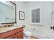 Bathroom features a decorative mirror, granite vanity, toilet, and plantation shutters at 809 Verney Ln, Charlotte, NC 28226