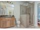 Bathroom showcasing a tiled shower with glass door, vanity, toilet, and decorative mirror at 809 Verney Ln, Charlotte, NC 28226