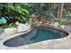 Secluded pool with stone accents and waterfall feature in a lush, landscaped backyard setting at 809 Verney Ln, Charlotte, NC 28226