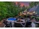 Backyard features a pool, fire pit surrounded by chairs, and landscaping with trees and shrubs at 8400 Prince Valiant Dr, Waxhaw, NC 28173