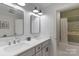 Bathroom with a double vanity, quartz countertops, and a tiled bathtub, providing a spa-like experience at 8400 Prince Valiant Dr, Waxhaw, NC 28173