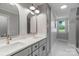 Bright bathroom featuring double sinks, quartz countertops, arched mirrors, and modern fixtures at 8400 Prince Valiant Dr, Waxhaw, NC 28173