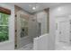 Modern bathroom with frameless glass shower, neutral tiling, and a window that provides natural light and a relaxing view at 8400 Prince Valiant Dr, Waxhaw, NC 28173