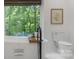 Bright bathroom featuring a freestanding tub, sleek black fixtures and a large window overlooking private backyard at 8400 Prince Valiant Dr, Waxhaw, NC 28173
