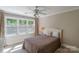 Well-lit bedroom featuring a ceiling fan and a large window, creating a relaxing atmosphere at 8400 Prince Valiant Dr, Waxhaw, NC 28173