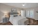 Bedroom with hardwood floors, large windows and a balcony that allows for natural light and serene outdoor views at 8400 Prince Valiant Dr, Waxhaw, NC 28173