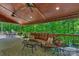 Inviting covered deck features a cozy seating area, ceiling fans, and views of the surrounding lush greenery at 8400 Prince Valiant Dr, Waxhaw, NC 28173