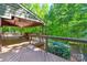 Covered deck featuring wood flooring, a ceiling fan, and an outdoor seating area overlooking a wooded backyard at 8400 Prince Valiant Dr, Waxhaw, NC 28173