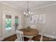 Cozy dining area featuring a round table, chandelier, and access to the outdoor deck at 8400 Prince Valiant Dr, Waxhaw, NC 28173