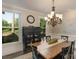 Formal dining room featuring dark wood floors, black hutch and chairs, natural light, and an elegant chandelier at 8400 Prince Valiant Dr, Waxhaw, NC 28173