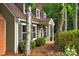 Close-up of the home's exterior with green siding and brown shutters, surrounded by nature at 8400 Prince Valiant Dr, Waxhaw, NC 28173