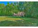 Exterior view of a home on a vast lawn surrounded by mature trees providing shade and privacy at 8400 Prince Valiant Dr, Waxhaw, NC 28173