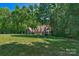 Scenic view of a home in the woods with a large green lawn at 8400 Prince Valiant Dr, Waxhaw, NC 28173