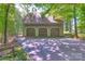 Spacious three-car garage exterior featuring an asphalt driveway and mature trees surrounding the property at 8400 Prince Valiant Dr, Waxhaw, NC 28173