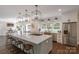 Bright, open kitchen featuring a large center island with seating, pendant lights, and stainless steel appliances at 8400 Prince Valiant Dr, Waxhaw, NC 28173