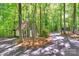 Exterior view of a rustic outbuilding featuring lush greenery, a driveway, and a wooden fence at 8400 Prince Valiant Dr, Waxhaw, NC 28173