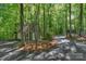 A charming outbuilding and driveway amidst a serene, wooded setting, offering extra space and privacy at 8400 Prince Valiant Dr, Waxhaw, NC 28173