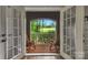 Covered outdoor patio with brick flooring, offering a view of the expansive green landscape at 8400 Prince Valiant Dr, Waxhaw, NC 28173