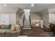 Basement staircase leading to the workout room, surrounded by a comfortable living area with hardwood flooring at 8400 Prince Valiant Dr, Waxhaw, NC 28173