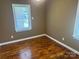 This bedroom is a blank canvas with hardwood floors and a window with blinds, ready for your personal touch at 907 Mcgowan Rd, Shelby, NC 28150