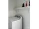 Bright laundry room featuring a dryer, overhead shelves, and storage for laundry supplies at 907 Mcgowan Rd, Shelby, NC 28150