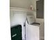 Bright laundry room featuring a white washing machine, overhead shelves and a storage area at 907 Mcgowan Rd, Shelby, NC 28150