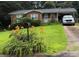 Charming brick home with a well-maintained lawn, covered parking, and vibrant flower beds at 910 Mcgowan Rd, Shelby, NC 28150