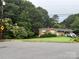 Exterior shot of a brick home with a well-maintained lawn and mature trees in a serene neighborhood at 910 Mcgowan Rd, Shelby, NC 28150