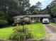 Charming brick home with a well-manicured lawn, colorful flowers, and a convenient carport at 910 Mcgowan Rd, Shelby, NC 28150